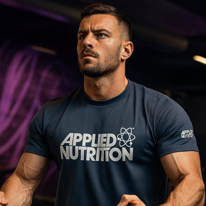 Man wearing navy Applied Nutrition t-shirt performing seated row in a gym with subtle MSS purple lighting in the background