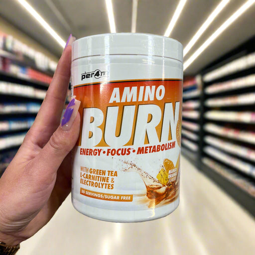 Close-up of (Per4m Amino Burn 240g) held up inside My Supplement Shop, clearly showing the front label in a Sports Nutrition setting.